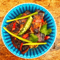 a bowl of rice with meat and vegetables in it